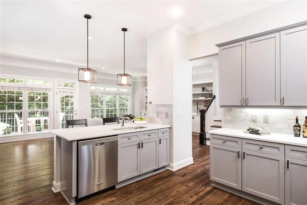 A view from the kitchen into the living room and through to the rear deck. This is a very private home - no neighbors across from or behind this home. Updated kitchen features Honed marble counter tops and backsplash and newer stainless appliances.