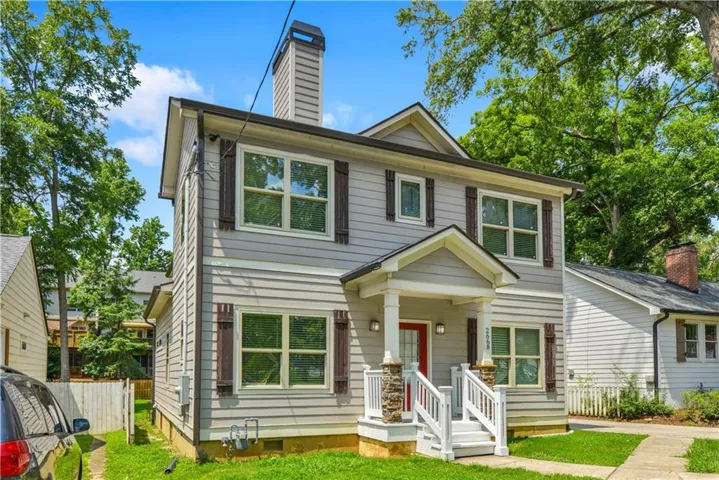 Two-story exterior featuring light gray siding, white trim, and dark brown window shutters