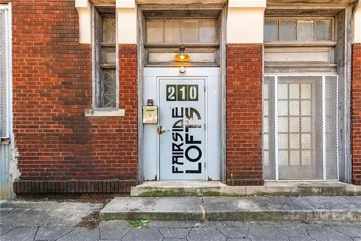 Brick facade with stone sills and a transom window above the entrance
