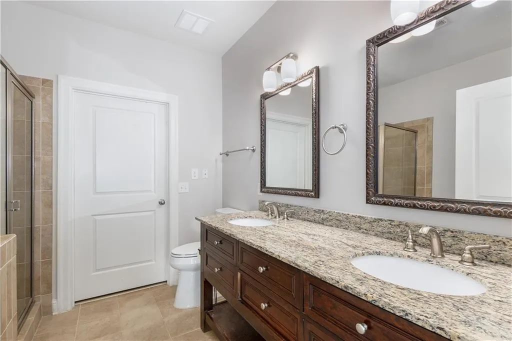 Full bath featuring a stall shower and light tile patterned flooring