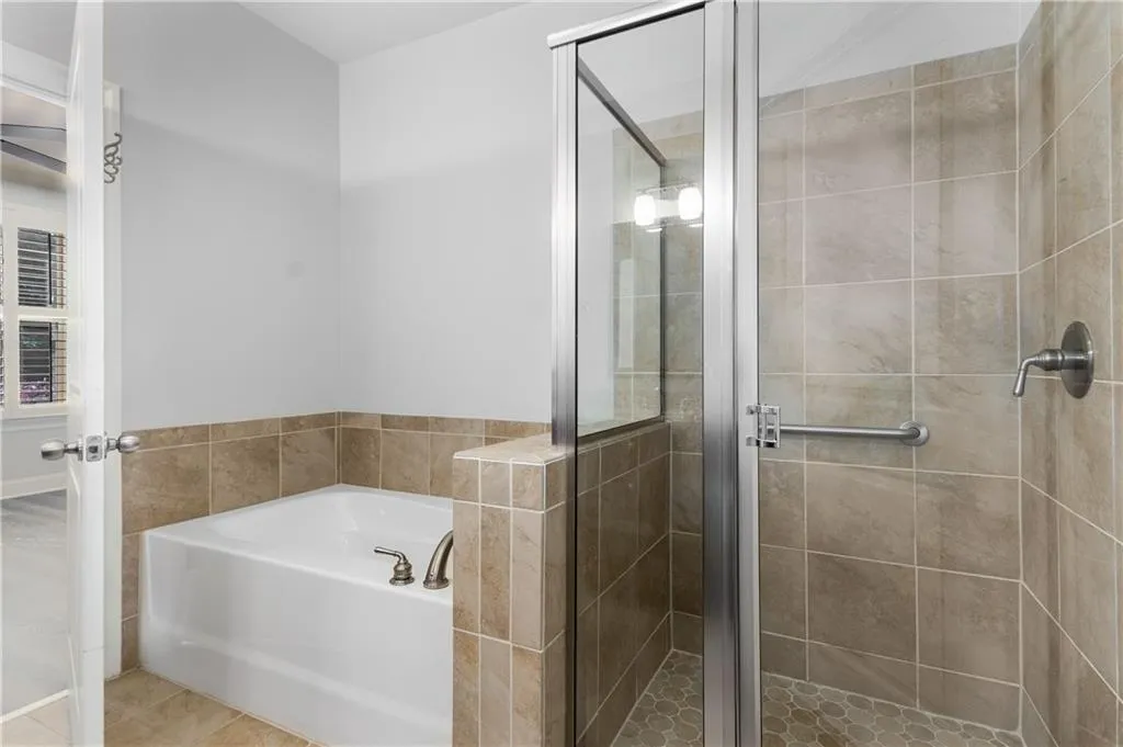 Full bath with a bath, a stall shower, and tile patterned floors