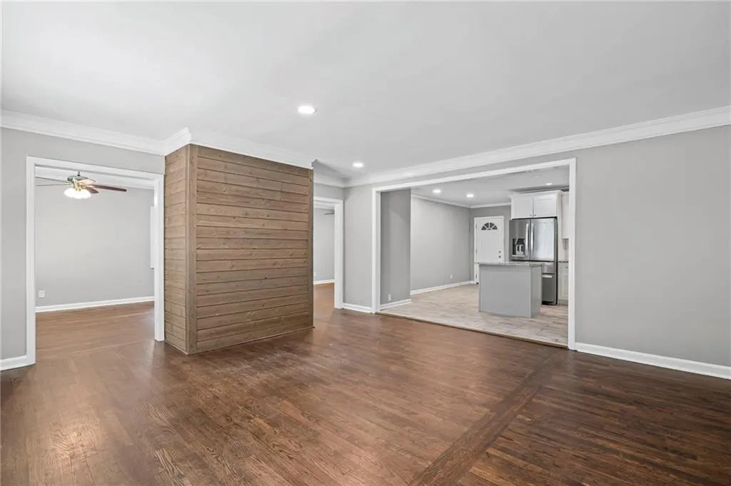 Unfurnished living room with dark wood-style flooring, crown molding, recessed lighting, and ceiling fan