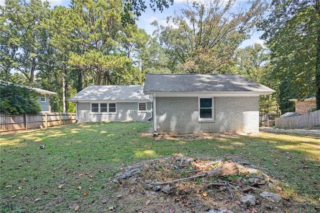 Back of property with brick siding and view of wooded area