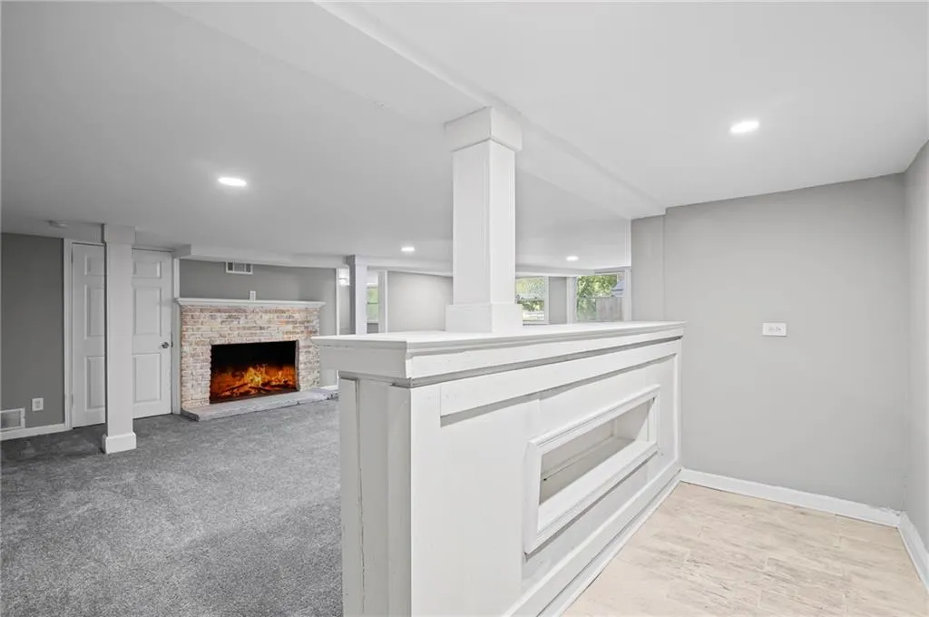 Kitchen featuring a brick fireplace, recessed lighting, and light countertops