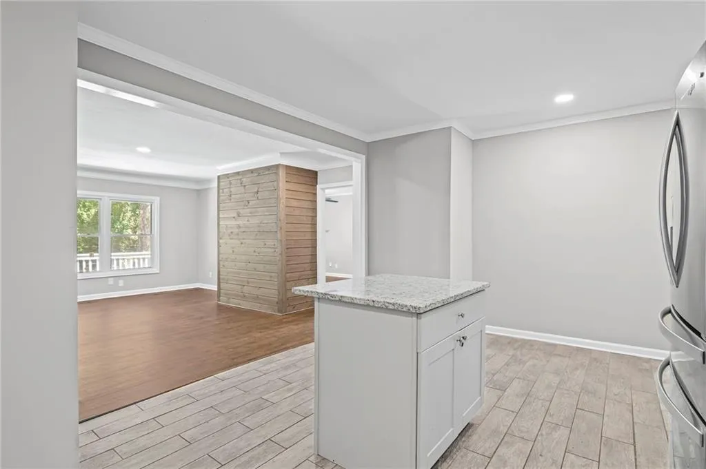Kitchen featuring white cabinetry, freestanding refrigerator, light wood finished floors, recessed lighting, and ornamental molding
