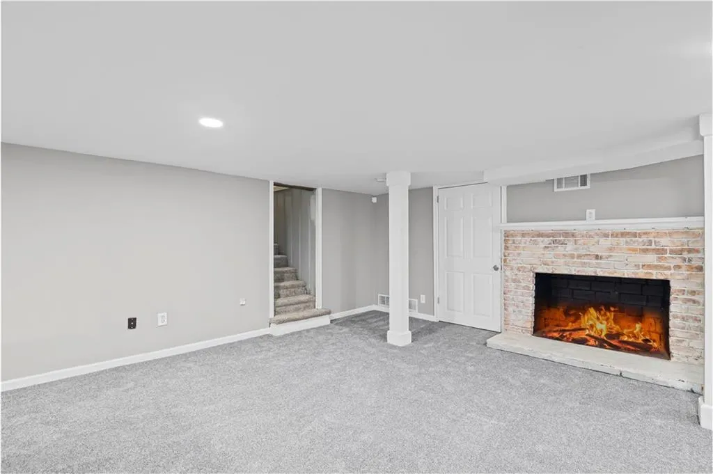 Finished basement featuring carpet, a fireplace, stairs, and recessed lighting