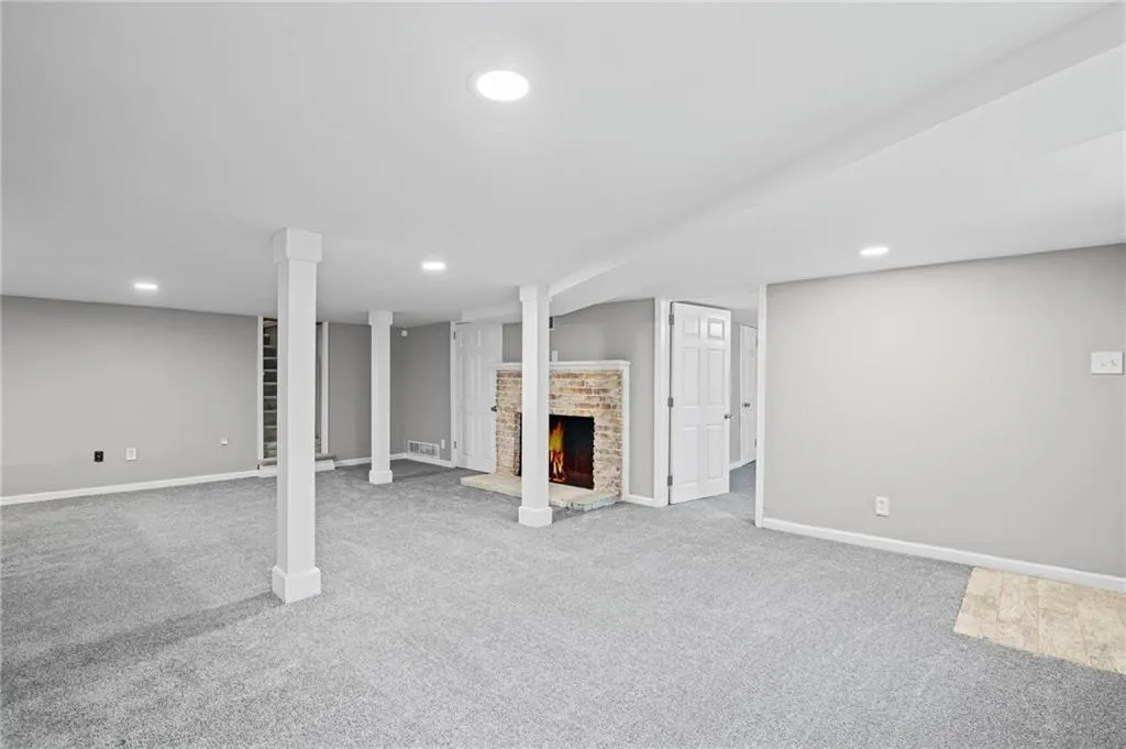 Finished below grade area featuring a fireplace, recessed lighting, and carpet floors