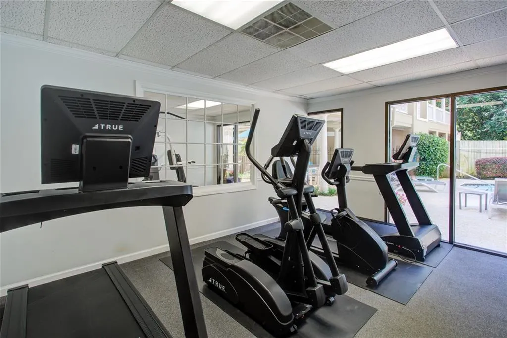 Workout area with a paneled ceiling and ornamental molding