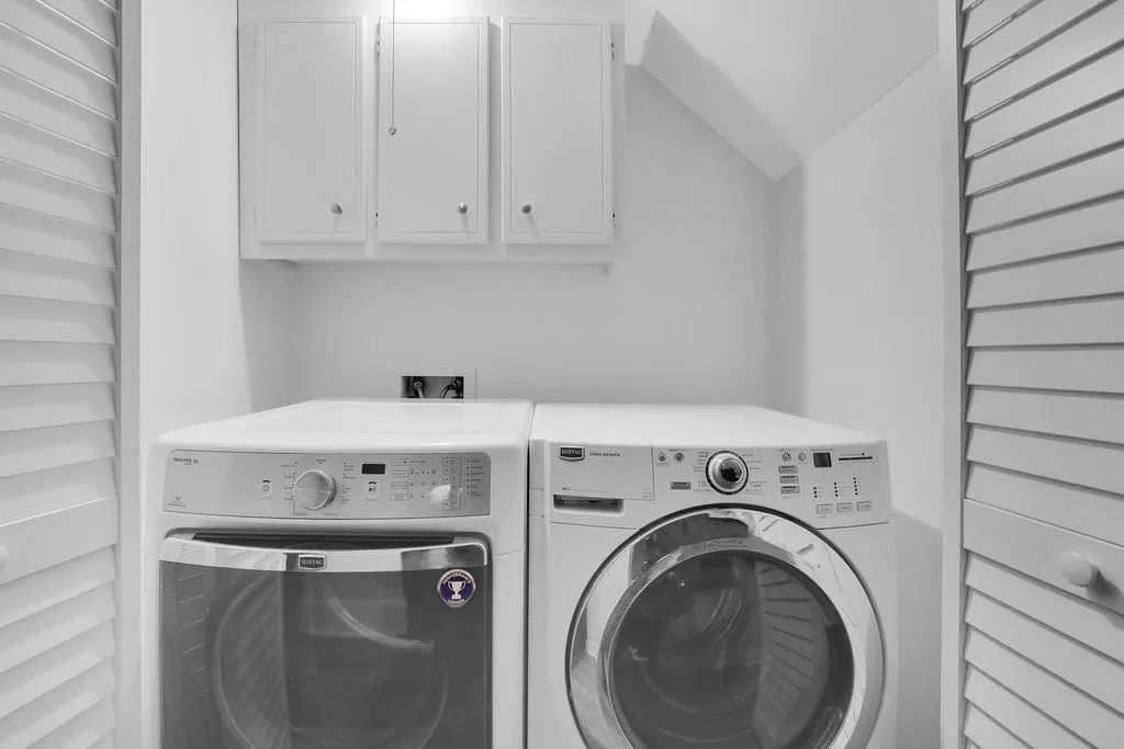 Laundry room with hookup for a washing machine, washing machine and clothes dryer, and cabinets