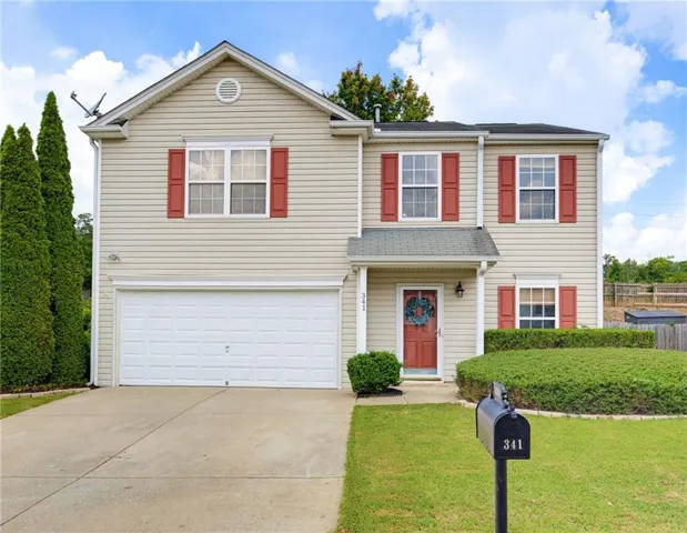 Two-story exterior with light-colored siding, red shutters, and a covered entryway