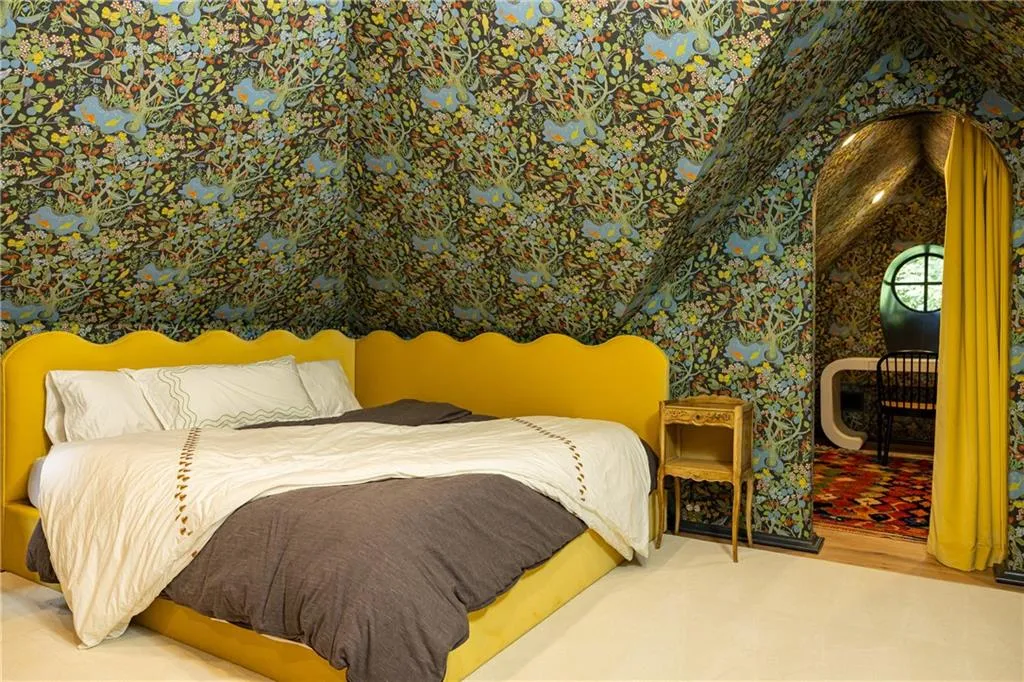 Designer wallpaper and a bold upholstered bed bring personality and charm to this secondary bedroom.