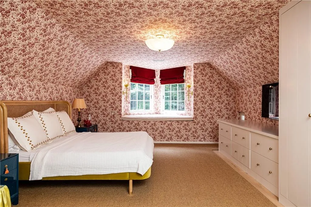 Charming secondary bedroom features whimsical wallpaper, built-in storage and abundant natural light.