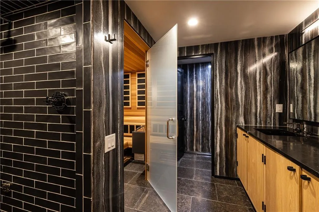 Terrace level features a beautifully designed full bath and sauna with dramatic finishes and a sleek, modern aesthetic.