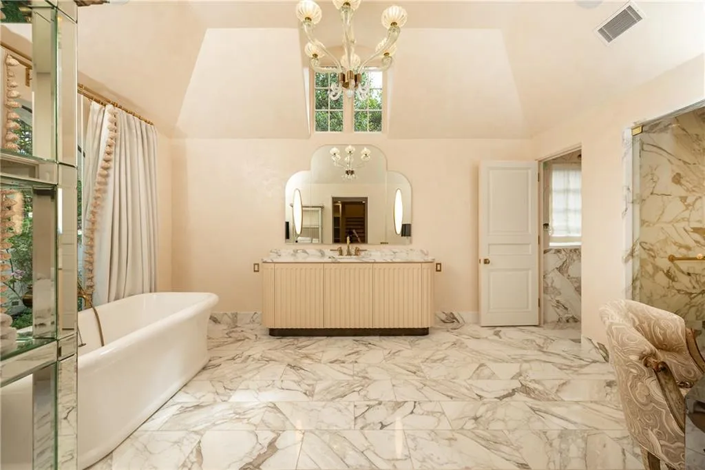 Luxurious marble primary bath features a freestanding soaking tub, expansive vanity and separate shower.