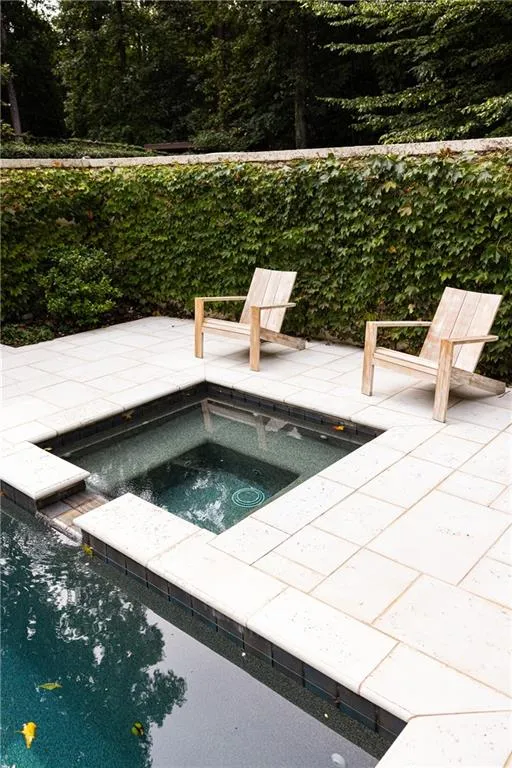 Poolside spa offers the perfect spot to unwind within the beautifully landscaped outdoor setting.