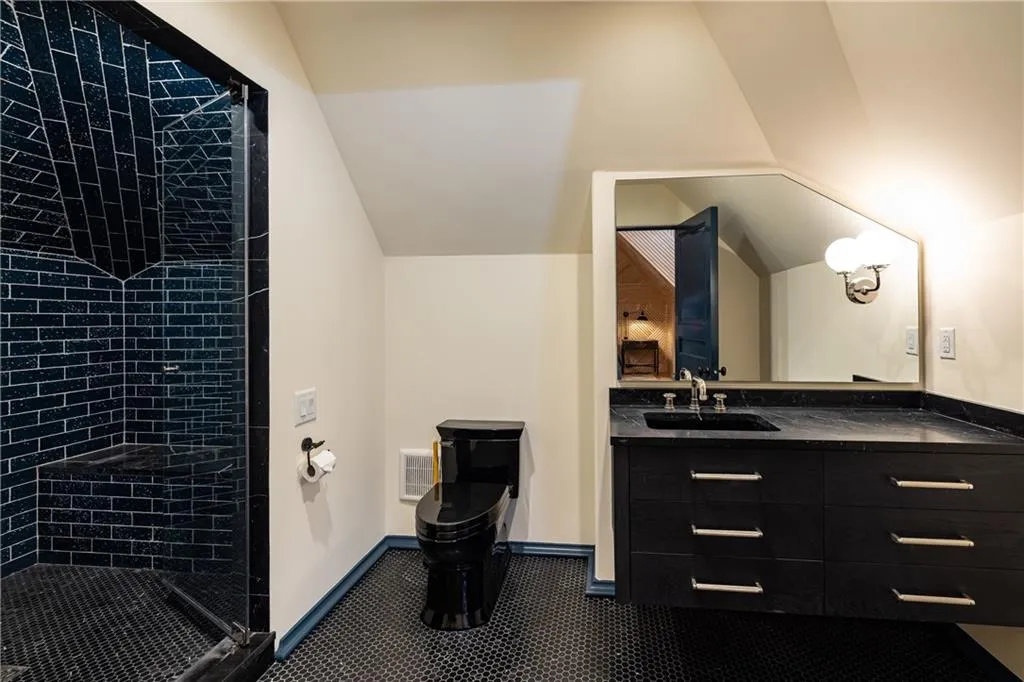 Private ensuite bath completes the wood-paneled secondary bedroom suite.