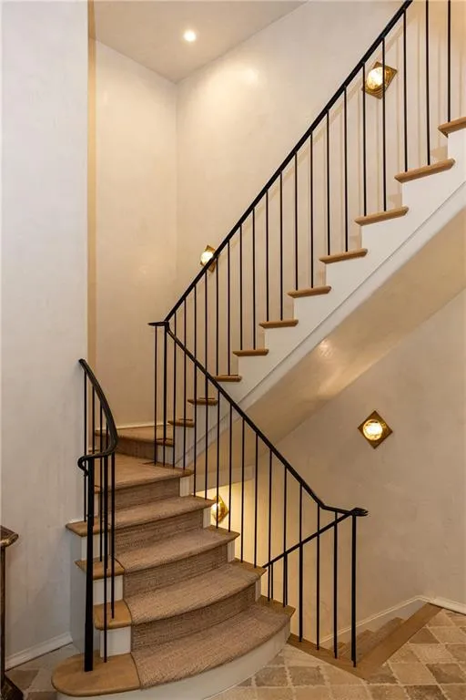 Graceful staircase leads to the home’s beautifully appointed upper level.
