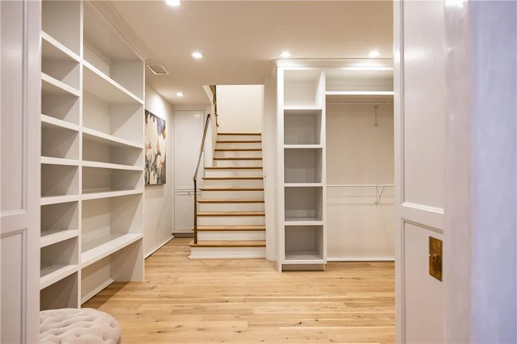 Extraordinary two-story dressing room offers exceptional custom storage and a staircase to the upper level.