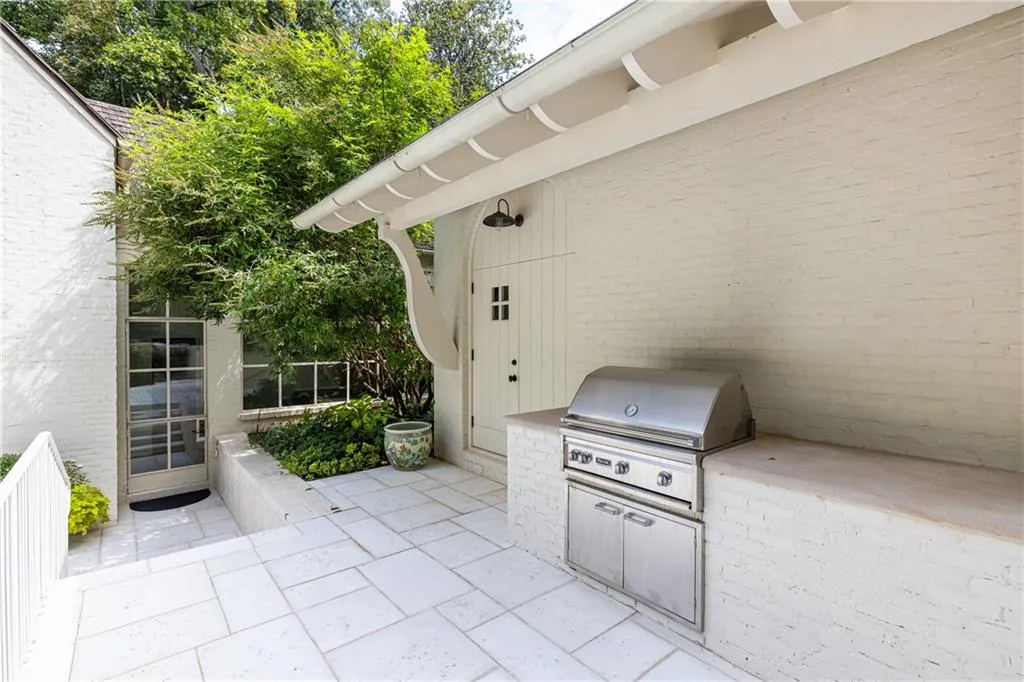 Outdoor kitchen with built-in Viking grill makes poolside dining and entertaining effortless.