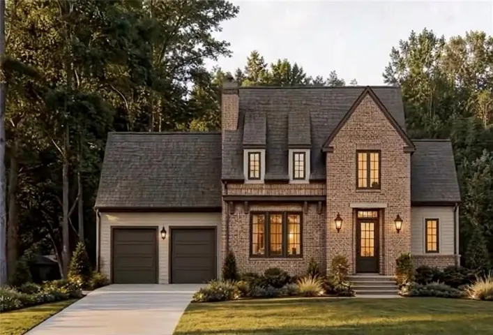 Brick and siding exterior featuring a multi-gabled roof, prominent chimney, two-car garage, and a concrete driveway