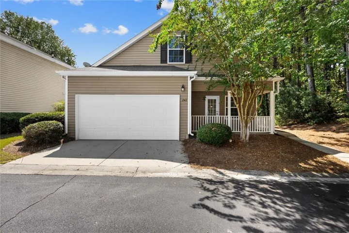 Siding exterior with a covered front porch, white railing, and a single-car garage