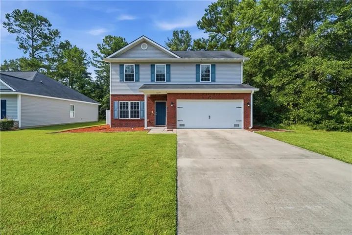 Two-story residence featuring a brick and siding exterior, a two-car garage, and a concrete driveway