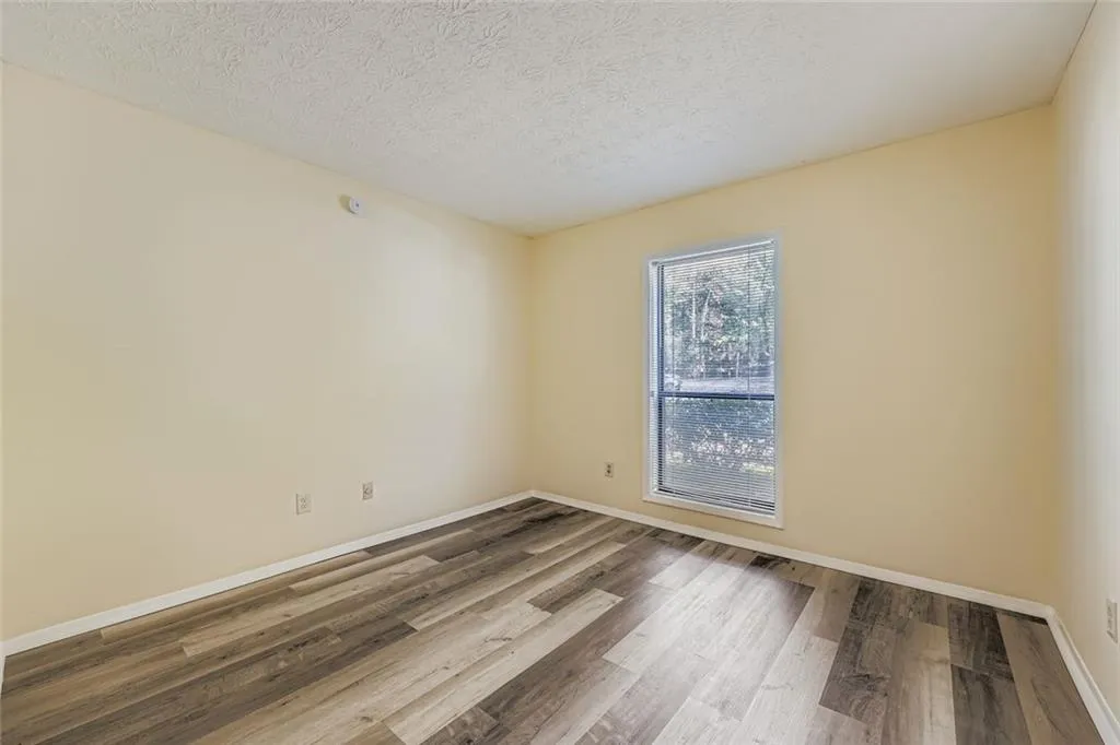Empty room featuring wood finished floors and a textured ceiling