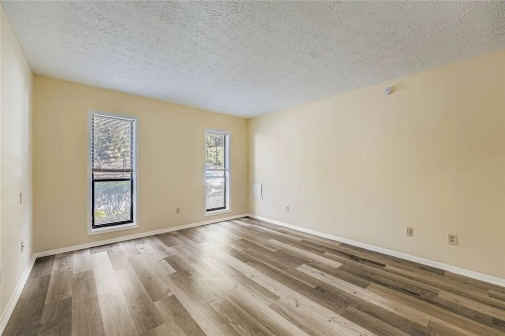 Unfurnished room with light wood-type flooring and a textured ceiling