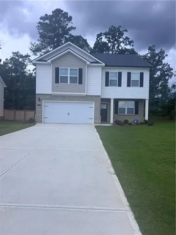 Two-story exterior with a two-car garage, brick and siding facade, and a concrete driveway