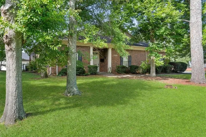 Brick exterior, covered entry, mature trees, manicured lawn, established landscaping