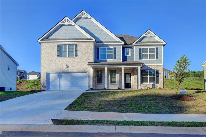 Two-story residence featuring light-colored brick and blue siding
