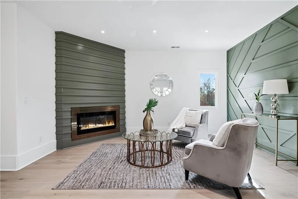 Living area with a large fireplace and light hardwood / wood-style floors Living area with a large fireplace and light hardwood / wood-style floors