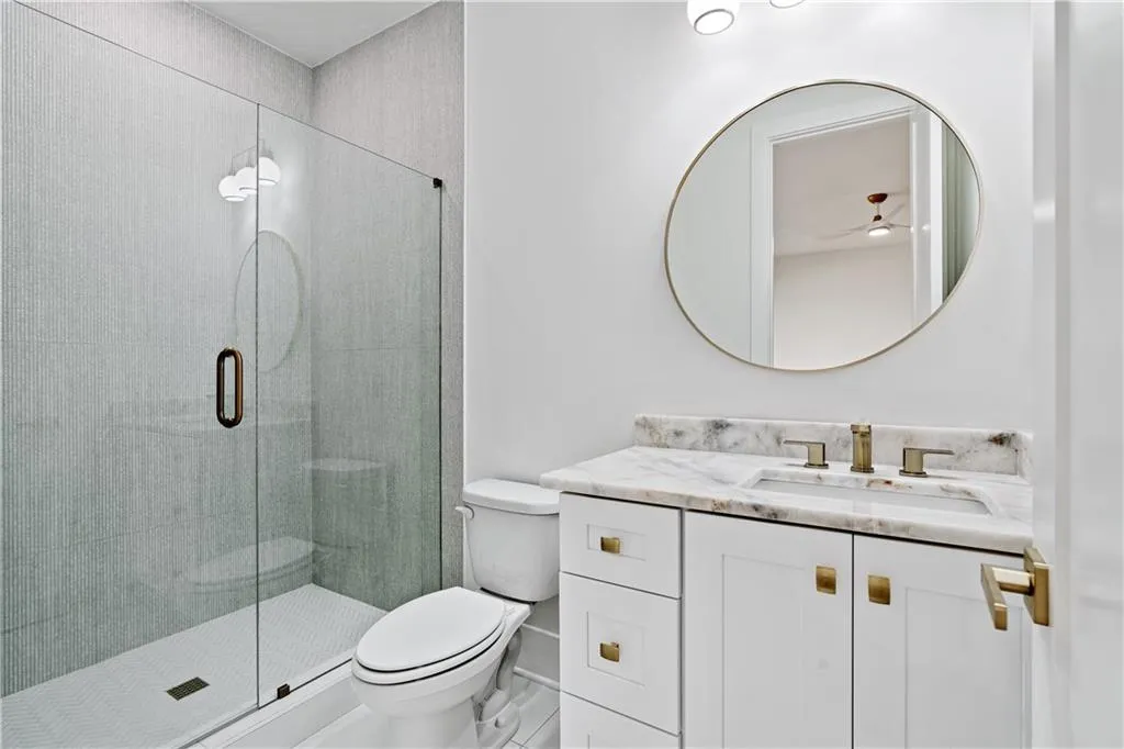 Bathroom featuring vanity, toilet, and an enclosed shower Bathroom featuring vanity, toilet, and an enclosed shower