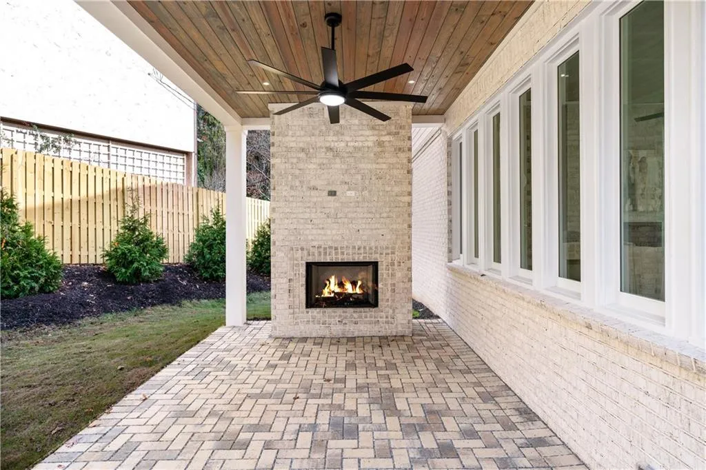 View of patio featuring an outdoor brick fireplace and ceiling fan View of patio featuring an outdoor brick fireplace and ceiling fan