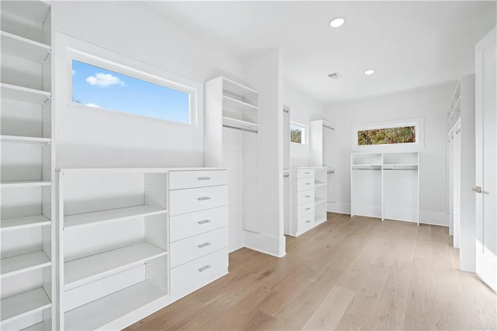 Spacious closet with light wood-type flooring Spacious closet with light wood-type flooring
