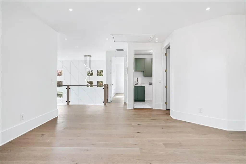 Unfurnished living room with sink and light hardwood / wood-style floors Unfurnished living room with sink and light hardwood / wood-style floors