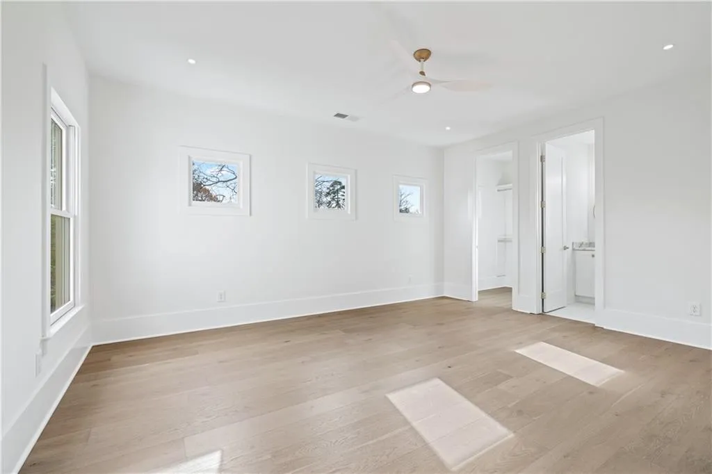 Empty room with ceiling fan and light hardwood / wood-style flooring Empty room with ceiling fan and light hardwood / wood-style flooring