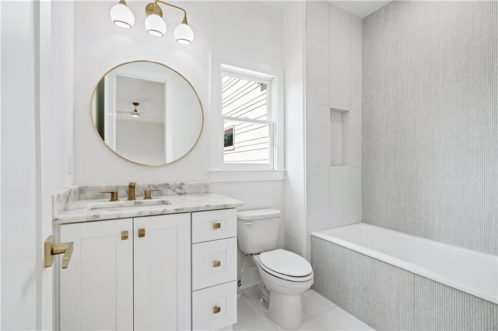 Bathroom featuring tile patterned floors, a tub to relax in, vanity, and toilet Bathroom featuring tile patterned floors, a tub to relax in, vanity, and toilet