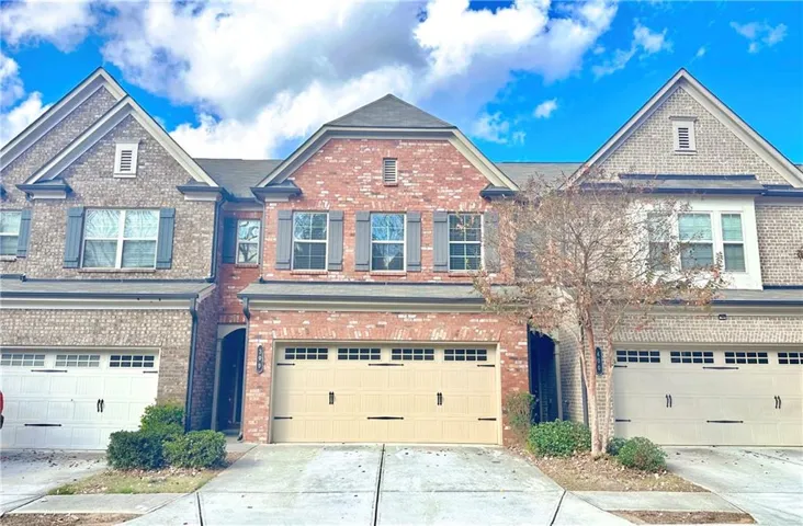 Brick and stone facade townhome with a two-car garage