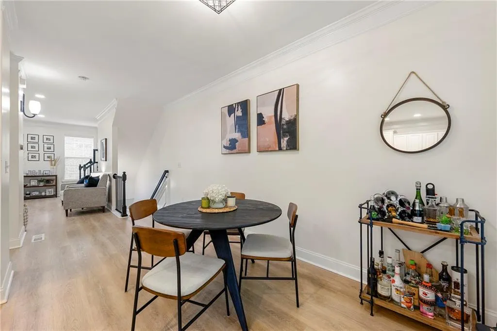Dining area with ornamental molding and light wood-type flooring