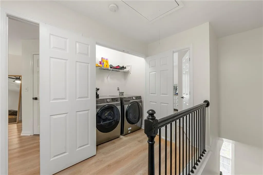 Laundry room with light hardwood / wood-style flooring and washer and clothes dryer