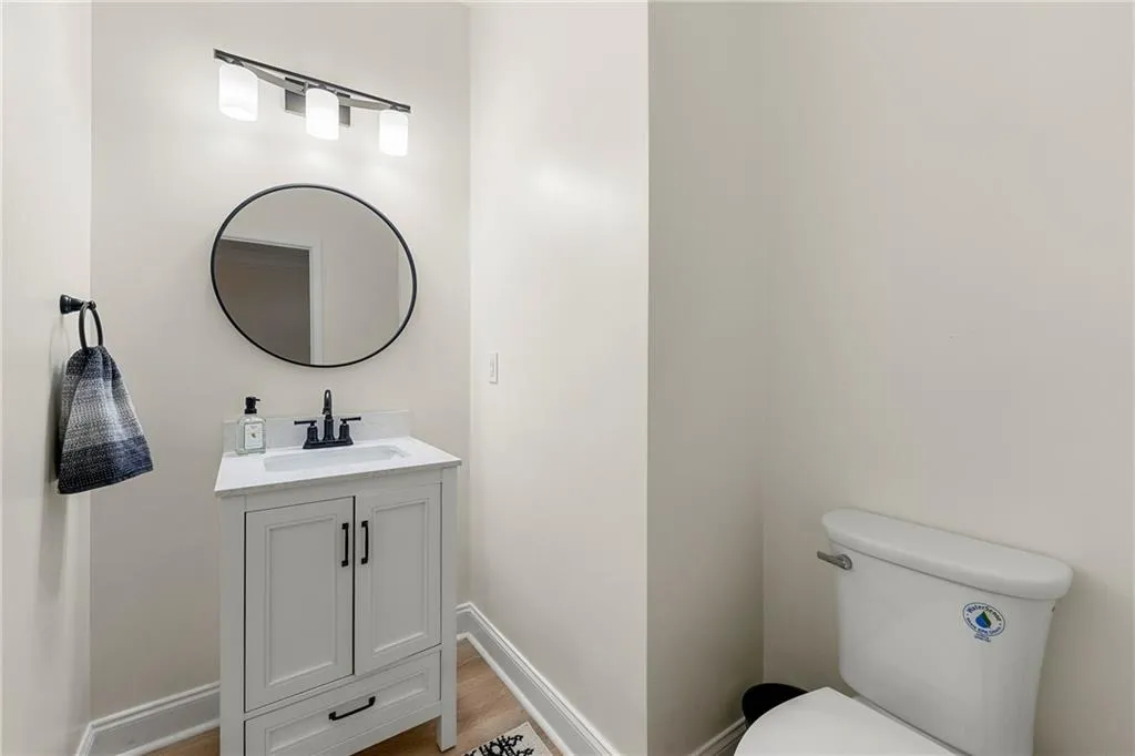 Bathroom with hardwood / wood-style floors, vanity, and toilet