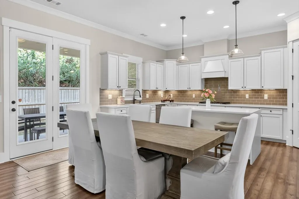 Dining space with ornamental molding, dark wood-type flooring, and recessed lighting