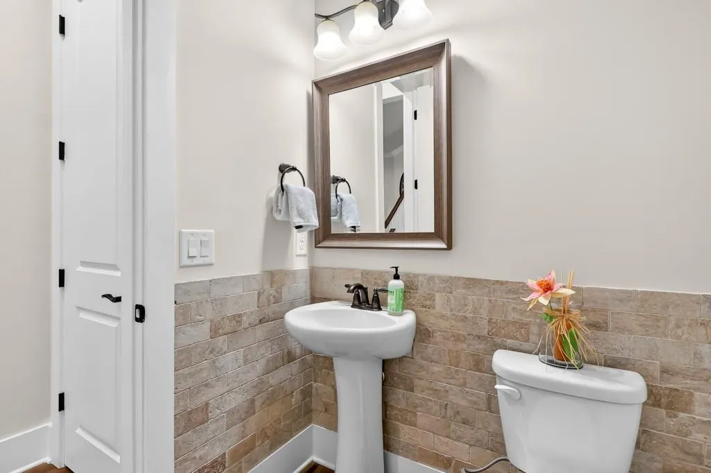 Half bathroom with tile walls