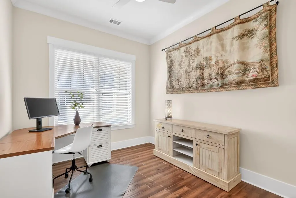 Office space with ornamental molding, dark wood-type flooring, and ceiling fan