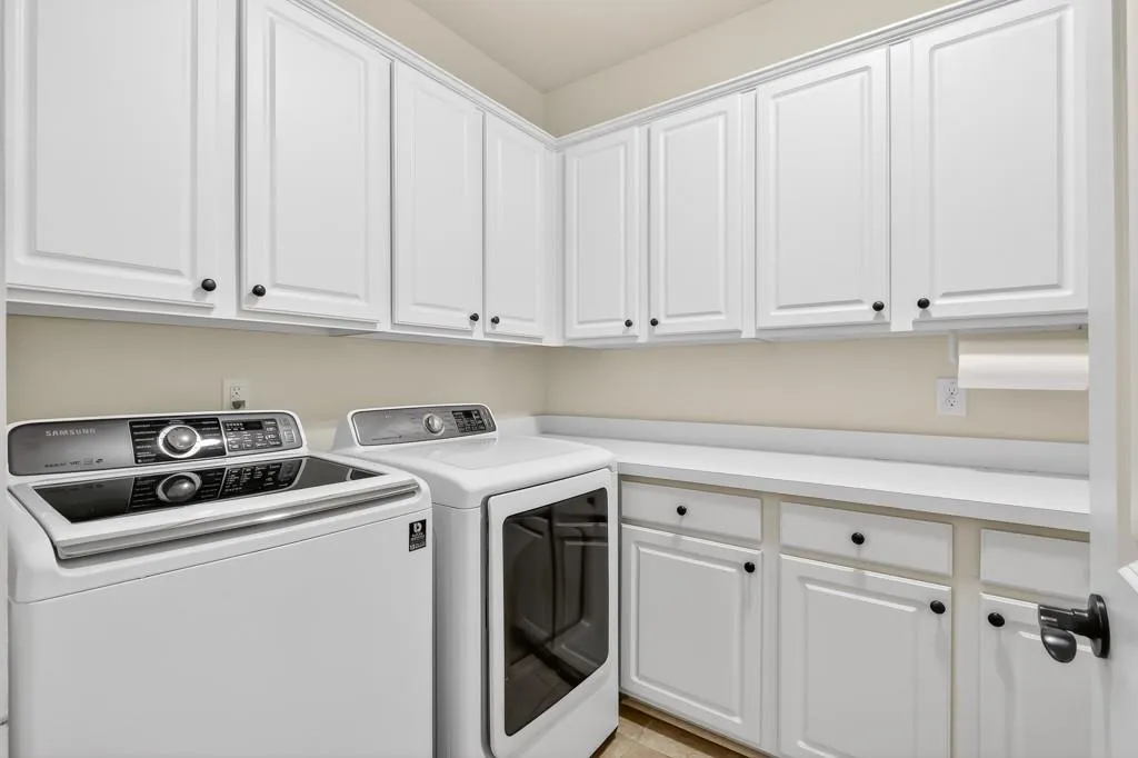 Laundry area featuring washer and dryer and cabinet space