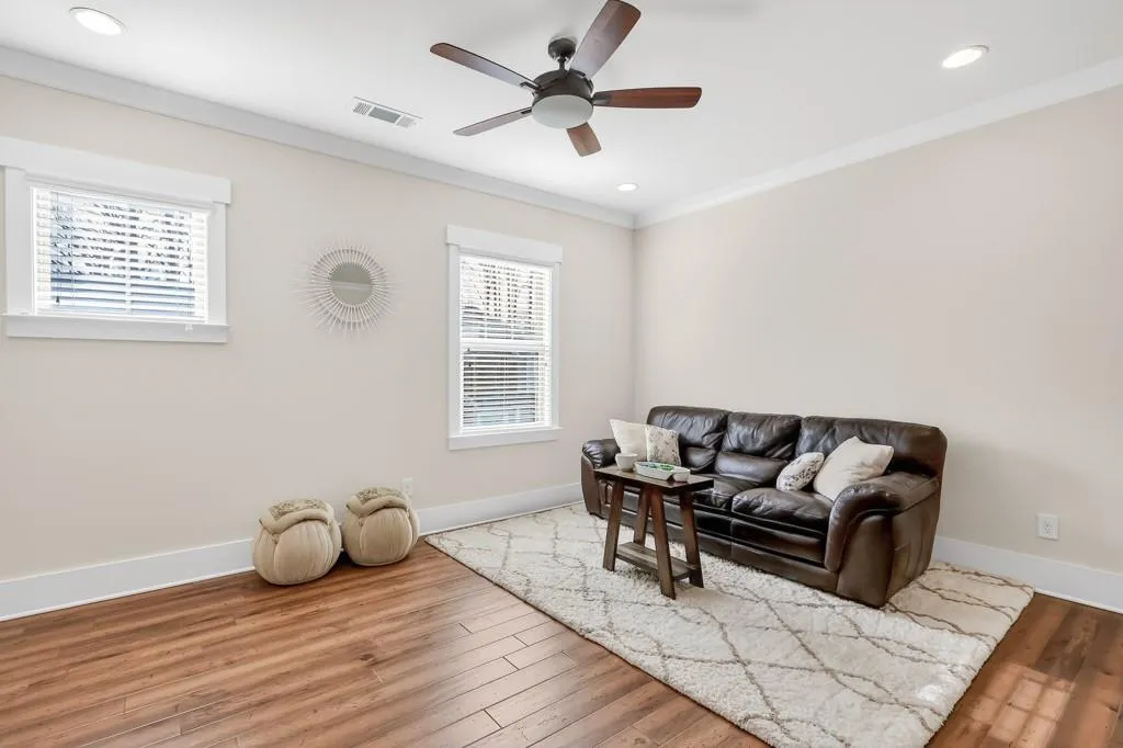 Living room with wood finished floors, ornamental molding, a ceiling fan, and recessed lighting