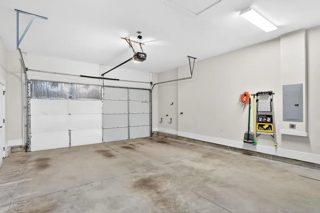 Garage with electric panel and a garage door opener