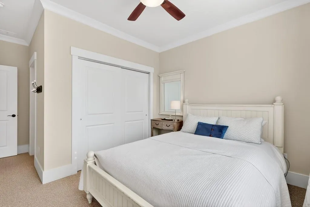 Bedroom featuring carpet, ornamental molding, ceiling fan, and a closet