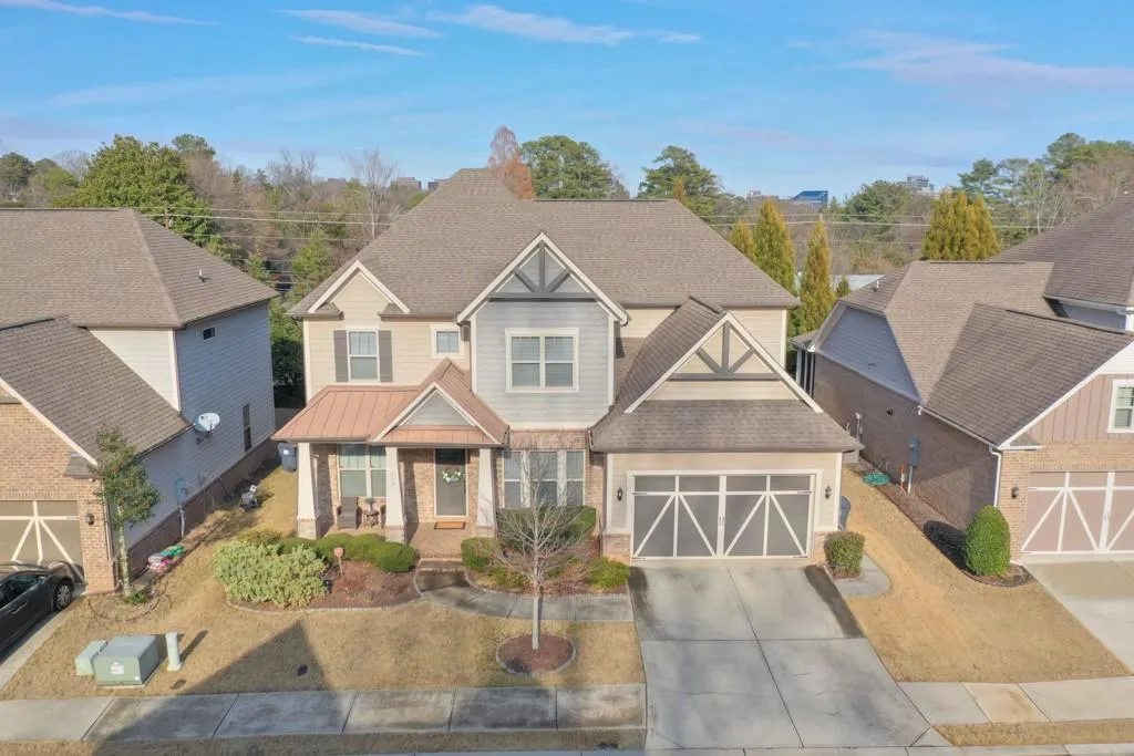 Craftsman-style home with roof with shingles, concrete driveway, a porch, brick siding, and an attached garage